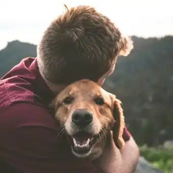 Hombre abrazando a su perro